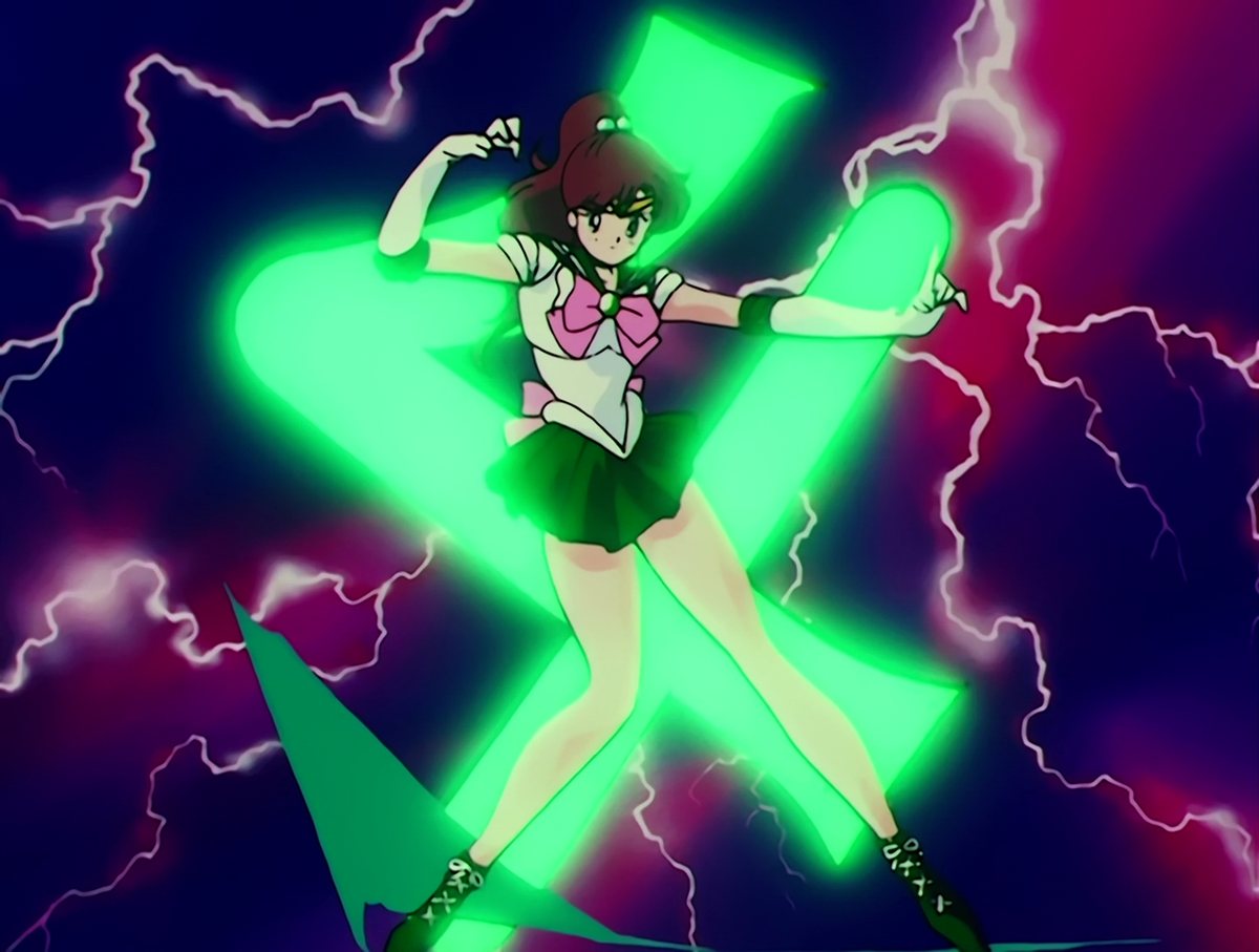 Sailor Jupiter landing the final pose of her transformation, the Jupiter glyph burning green behind her in a field of lightning.