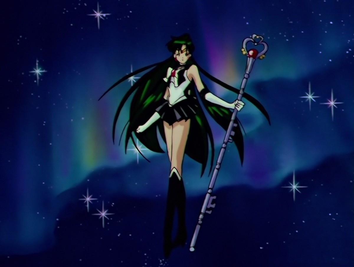 Sailor Pluto at the end of her transformation, the Garnet Rod in one hand and her long hair spread out, floating in a starry sky lit by a rainbow aurora.