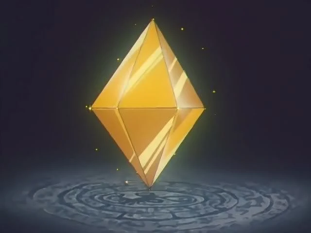 The Golden Crystal from the 90s anime: a gold eight-sided crystal glowing above a ring of carved stone, in the dark