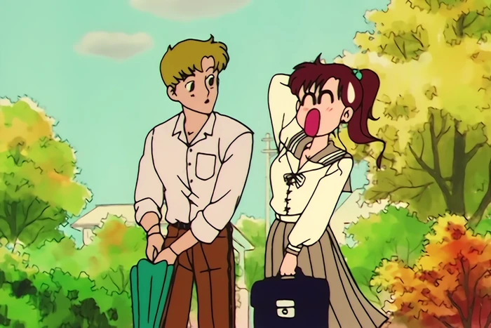 Makoto outside under the autumn trees beside the blond boy she likes, one hand behind her head and her mouth open mid-splutter while he turns to look at her