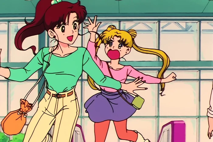 Makoto and Usagi out in daylight at the shopping centre, Makoto striding ahead laughing with a shopping bag on her arm and Usagi hurrying along beside her mid-complaint