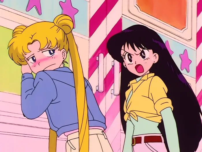 Rei shouting at Usagi outside the arcade while Usagi sulks with her cheek in her hand