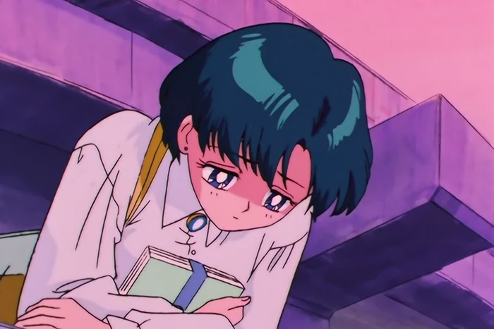 Ami leaning on a stairwell railing at dusk with a book held against her chest, looking down and away, unsmiling