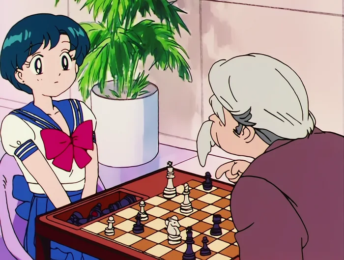 Ami playing chess across a table with an elderly opponent