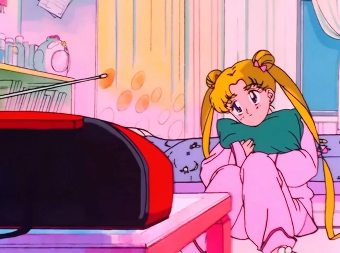 Usagi curled up on a sofa in pyjamas, hugging a cushion to her chest, listening to a record player