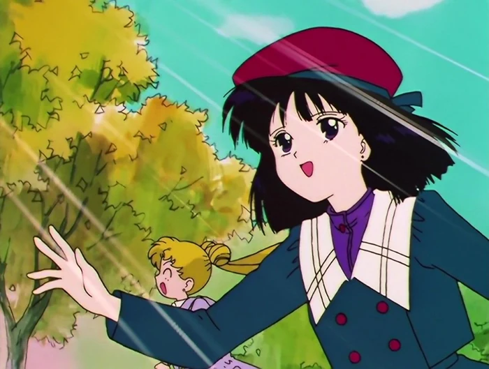 Hotaru outdoors on a bright day in a red beret and dark school coat, smiling and reaching out with one hand, a yellow-green tree beside her and Usagi behind