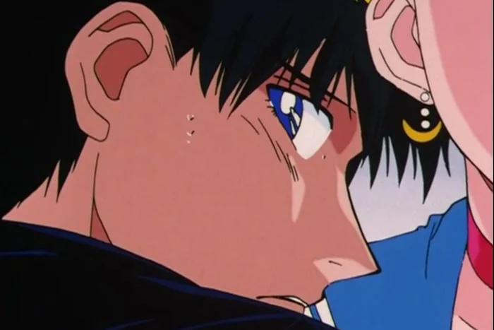 Close-up of Mamoru, sweating and wide-eyed, with Sailor Moon&rsquo;s cheek close against his