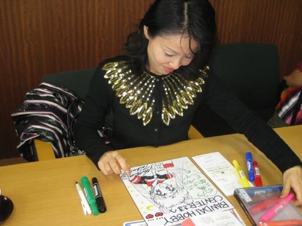 Naoko Takeuchi drawing at a desk with markers