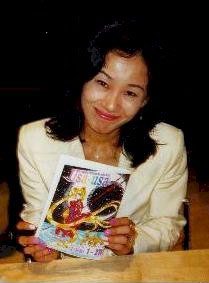 Naoko Takeuchi holding up an illustrated book, 1990s