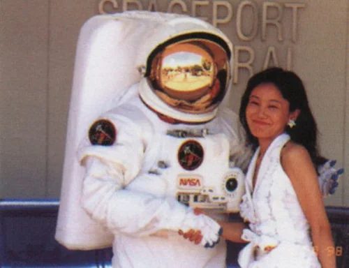 Naoko Takeuchi standing beside a NASA spacesuit