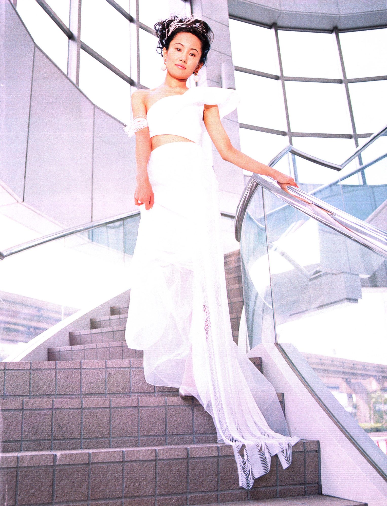 Naoko Takeuchi in a long white gown, descending a curved staircase