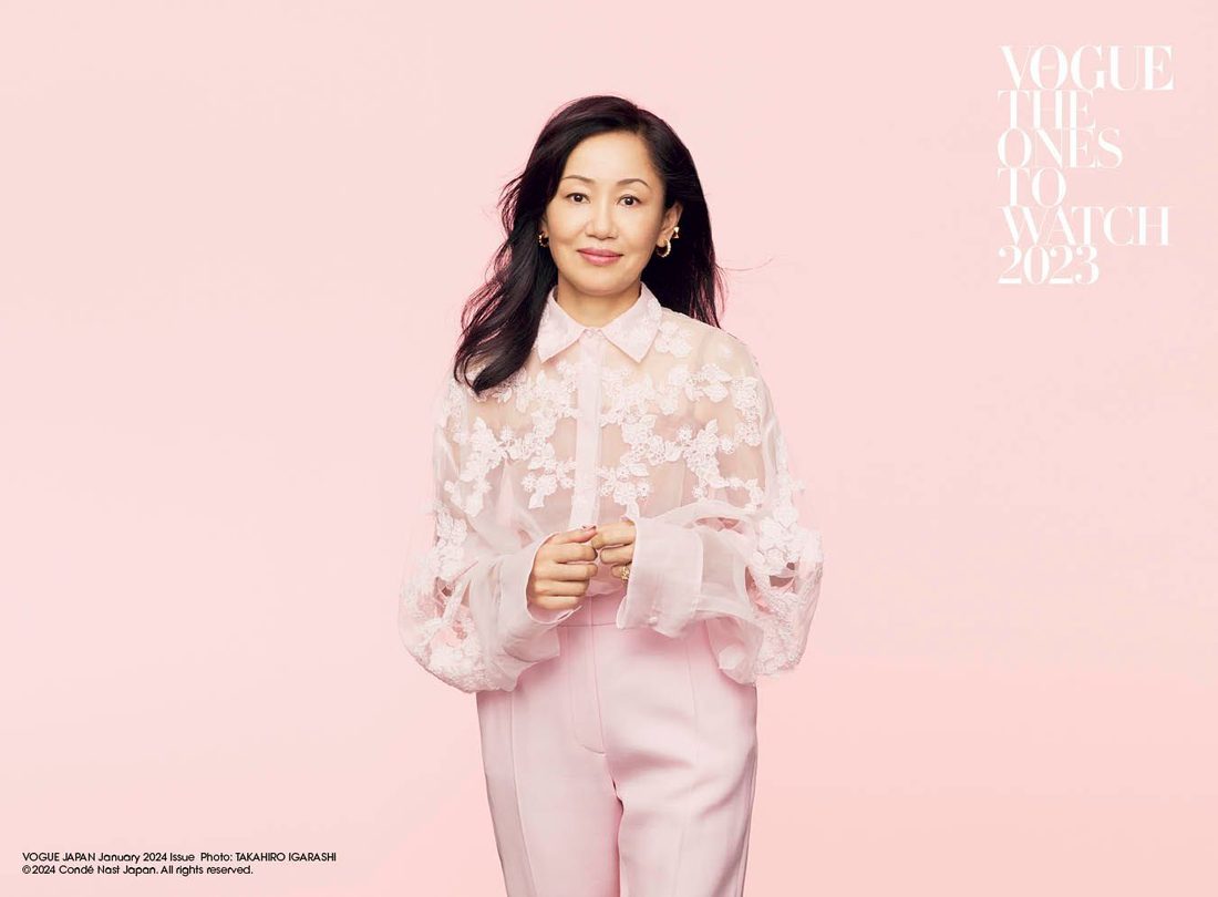 Naoko Takeuchi standing against a pale pink background in a sheer pink blouse with floral applique and full sleeves, and pink trousers. The page is headed Vogue, The Ones To Watch, 2023.